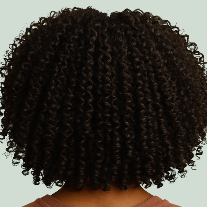 Close-up of a person with curly hair on a green background